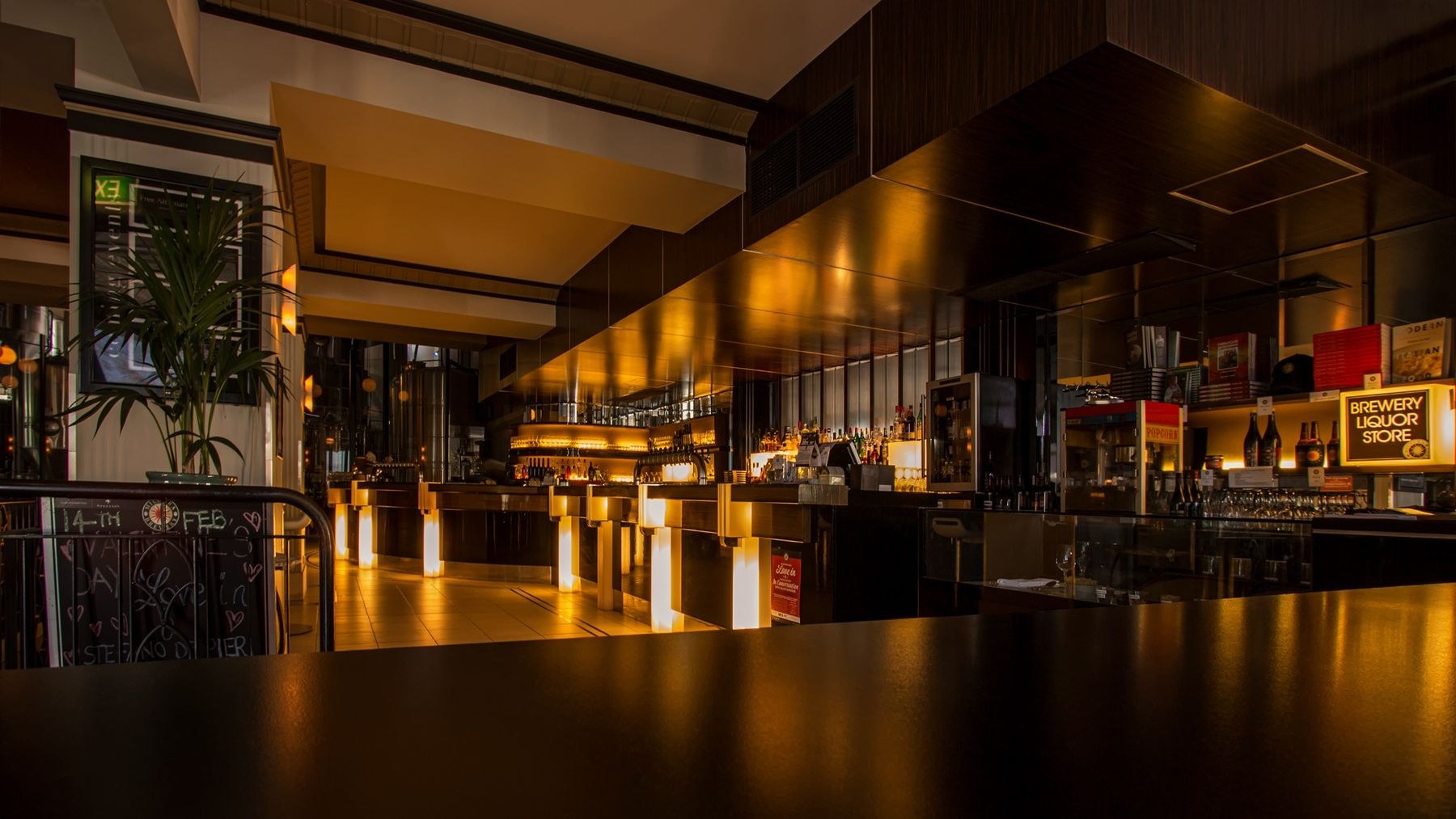 A warmly lit restaurant bar with inviting seating and pendant lights